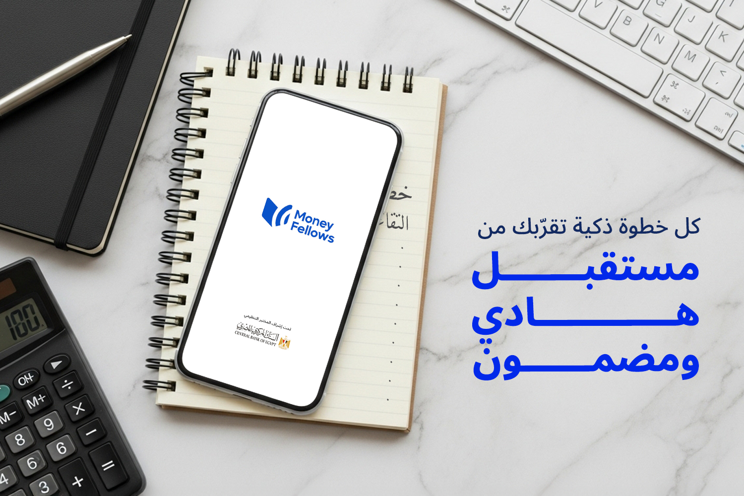 نوت بوك وفوقيها موبايل مفتوح على أبلكيشن ماني فيللوز وجنبهم آلة حاسبة وكي بورد من مقال 6 خطوات للتخطيط للمعاش بذكاء وراحة